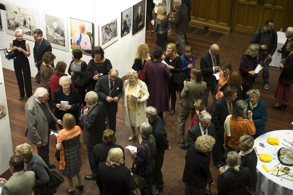 Basil Hetzel AC engaging with attendees at the opening of Avril Thomas's 'A Day in the Life of Medicine' exhibition, University of Adelaide School of Medicine, featuring medical portrait