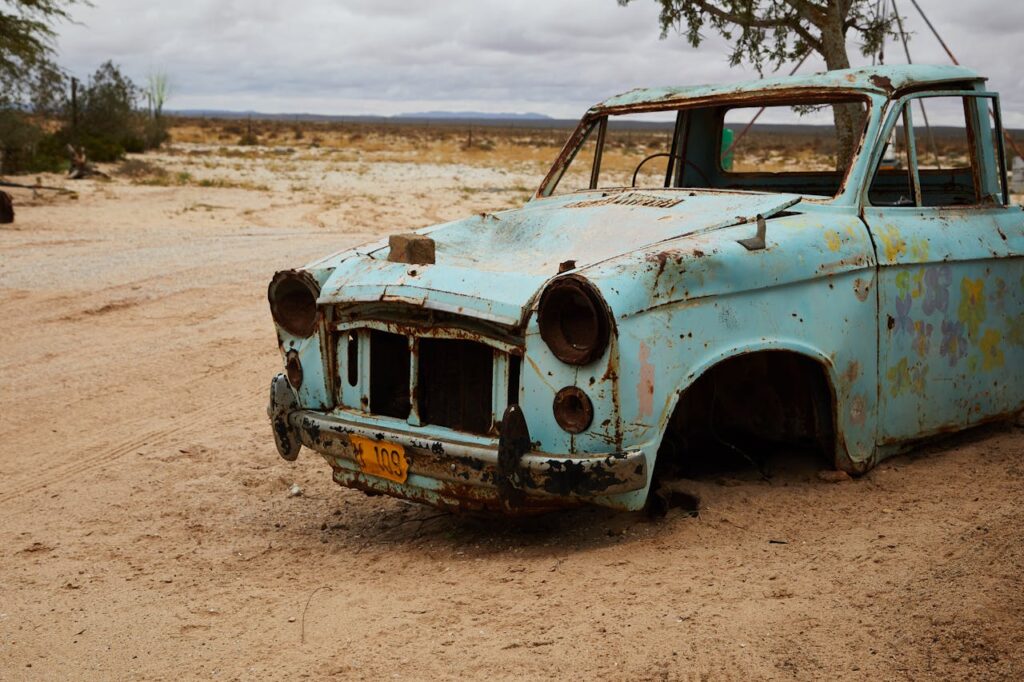 a rusting scrap vehicle in the desert