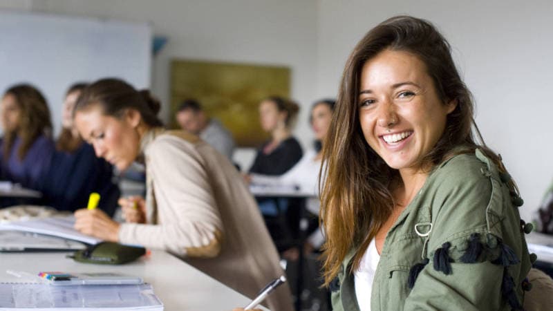A smiling Diploma of Mind Body Medicine student in a class session.