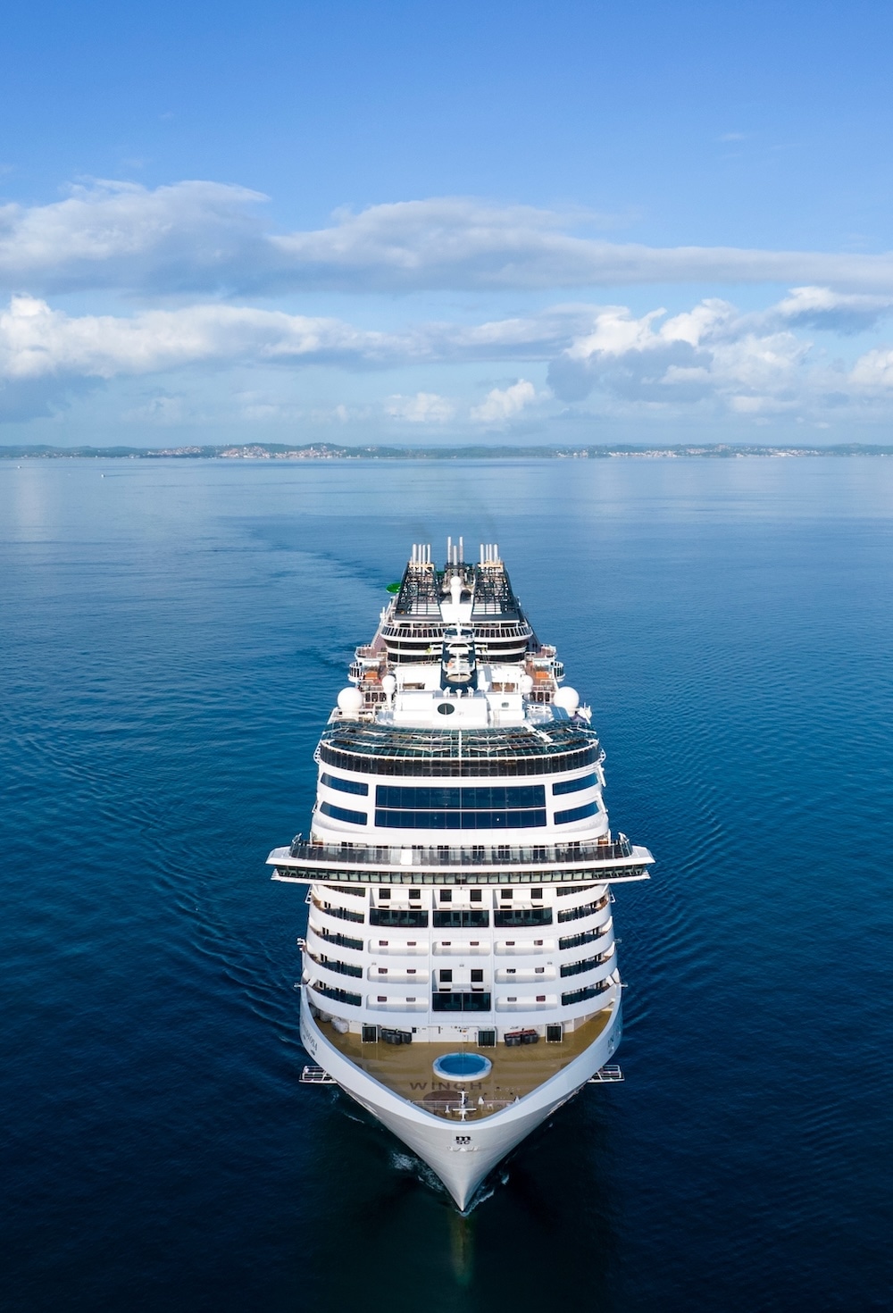 Luxurious large cruise ship sailing in calm blue waters and clear skies, Aerial view