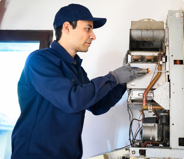 A plumber installing a modern hot water system in a residential property.