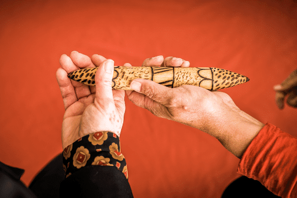 Passing a talking stick between hands demonstrating acceptance and reconciliation