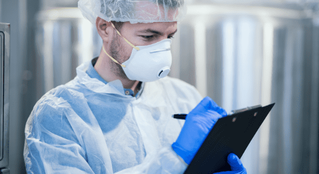 technologist-specialist-with-protective-mask-hairnet-holding-clipboard-checklist-writing-production-results technologist specialist