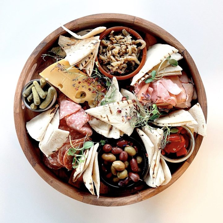 Tasting Platter with a selection of cold meats, marinated vegetables, olives, cheese and grilled flatbread.