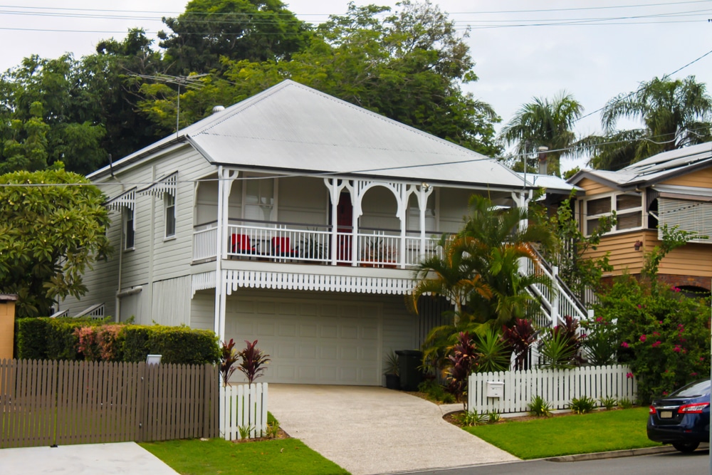 White,Queenslander,Home,With,Tropical,Greenery,And,Tall,Trees,On
