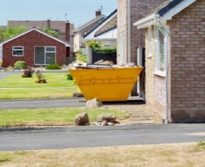 Skips Adelaide - What Not to Dispose of in Your Skip Bin in Adelaide - Yellow Skip Bin Beside the Houses