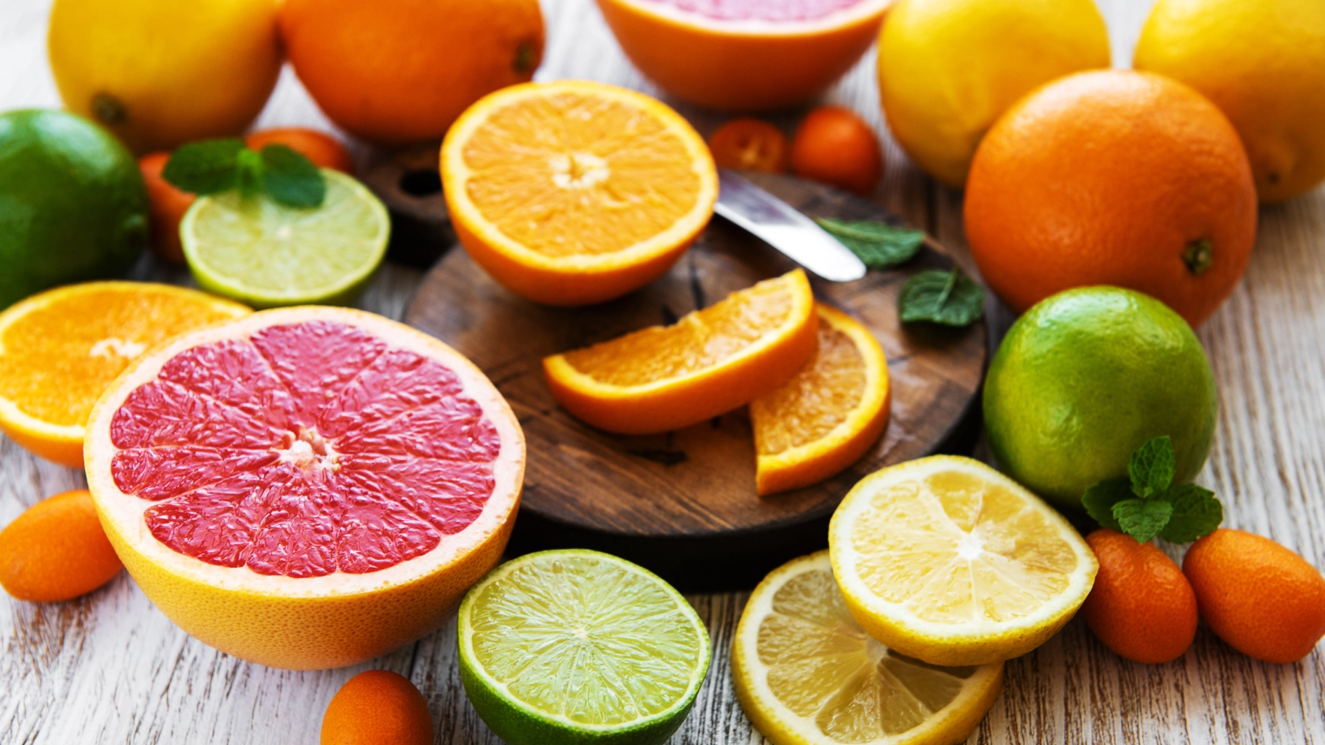 A colourful array of freshly sliced citrus fruits arranged on a wooden surface, best foods to improve immunity