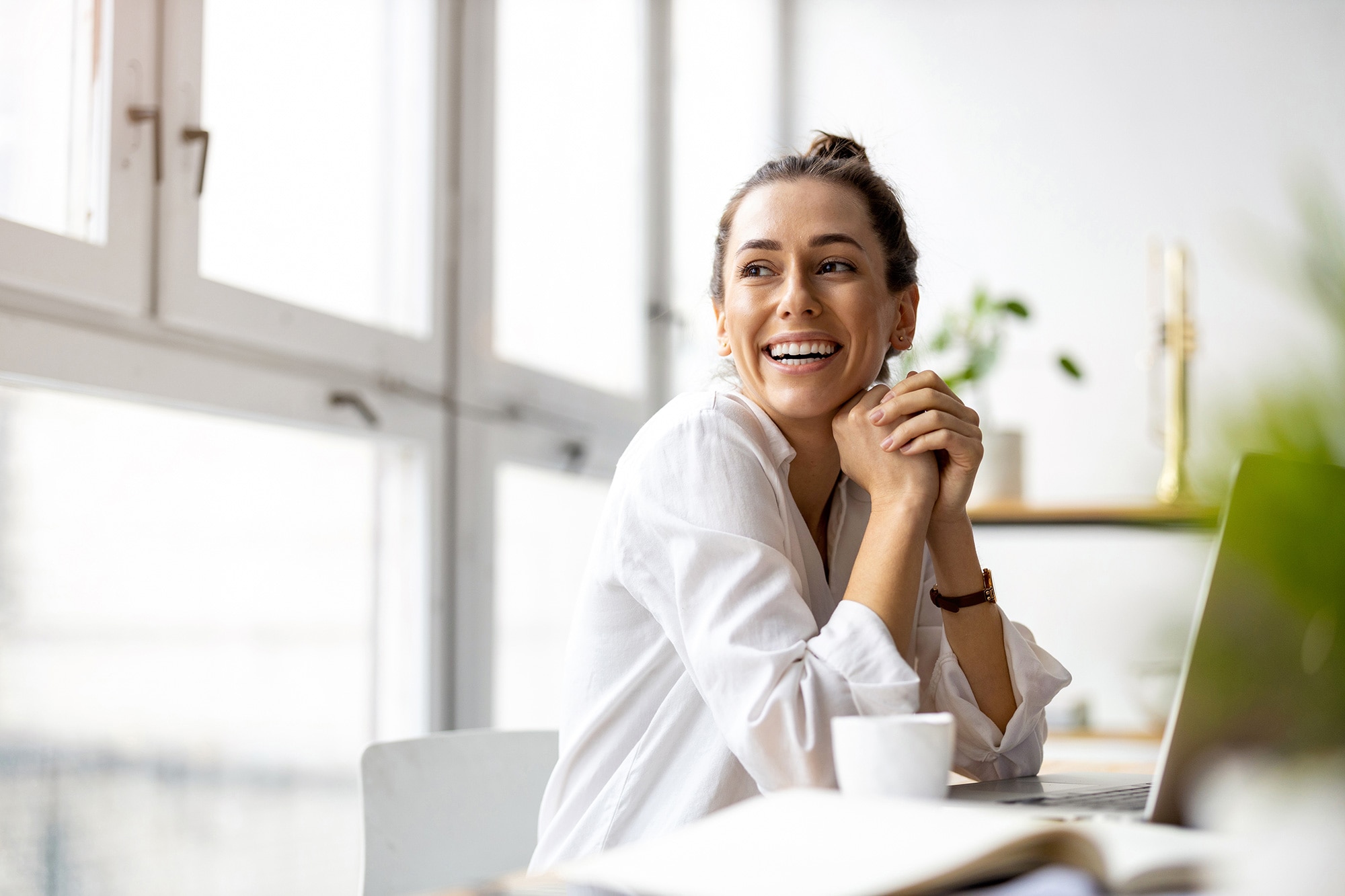 Photo of a happy, smiling woman sitting at a desk,
