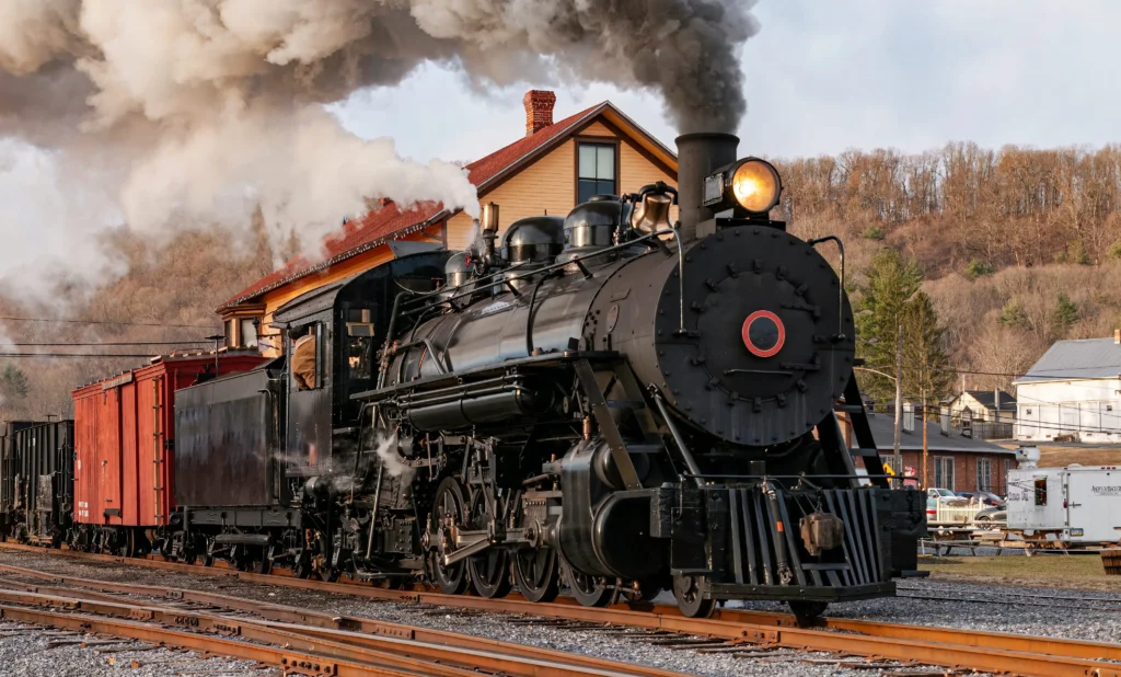 vintage steam train with blowing smoke on track | swoosh finance