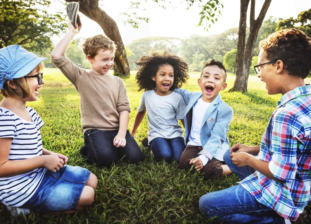five kids playing at a park on the grass | swoosh finance