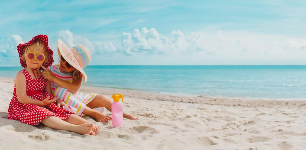two sisters wearing hats sitting at the beach | swoosh finance