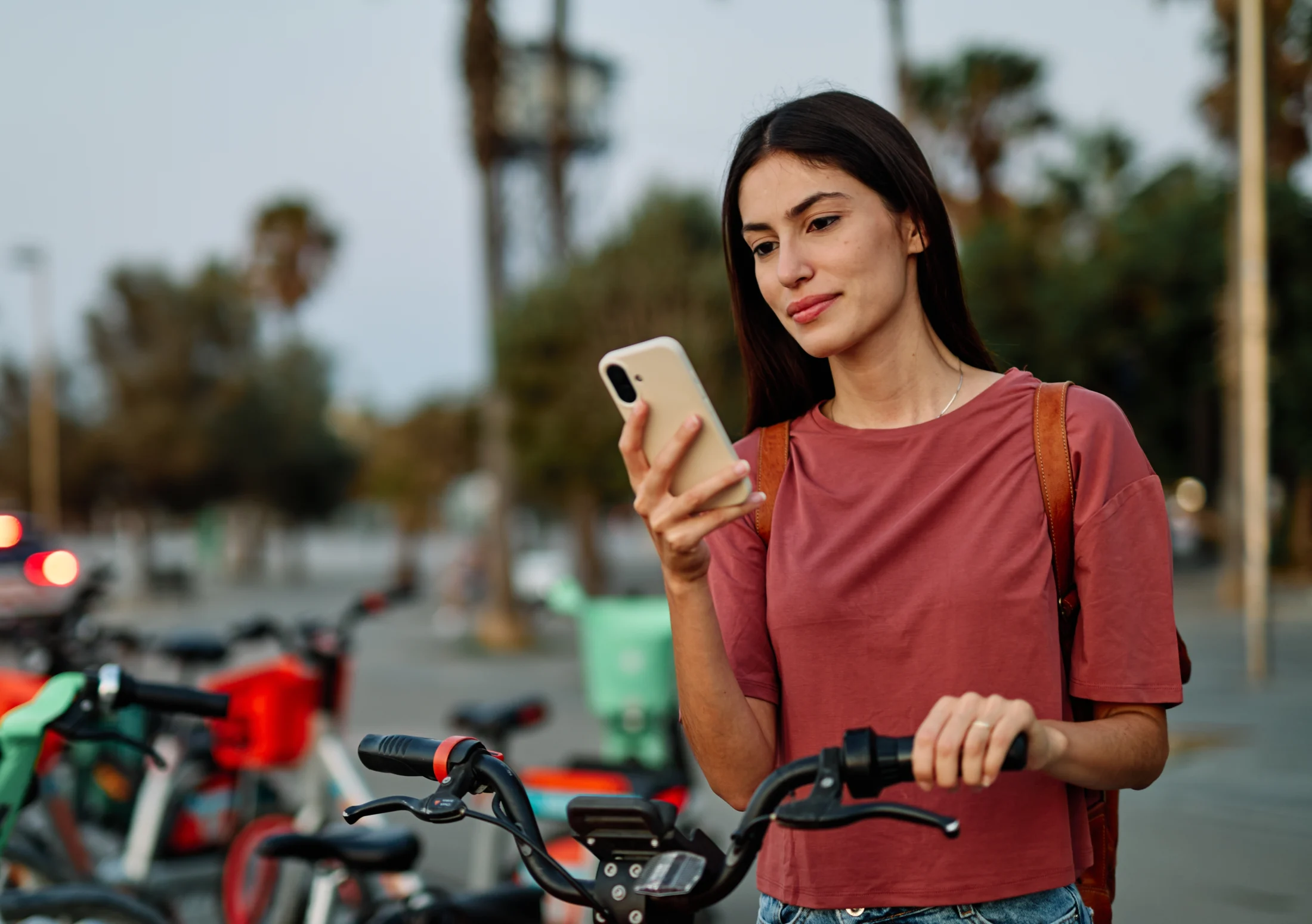 woman on a bike checking her phone; a guide to emergency loans | Swoosh Finance