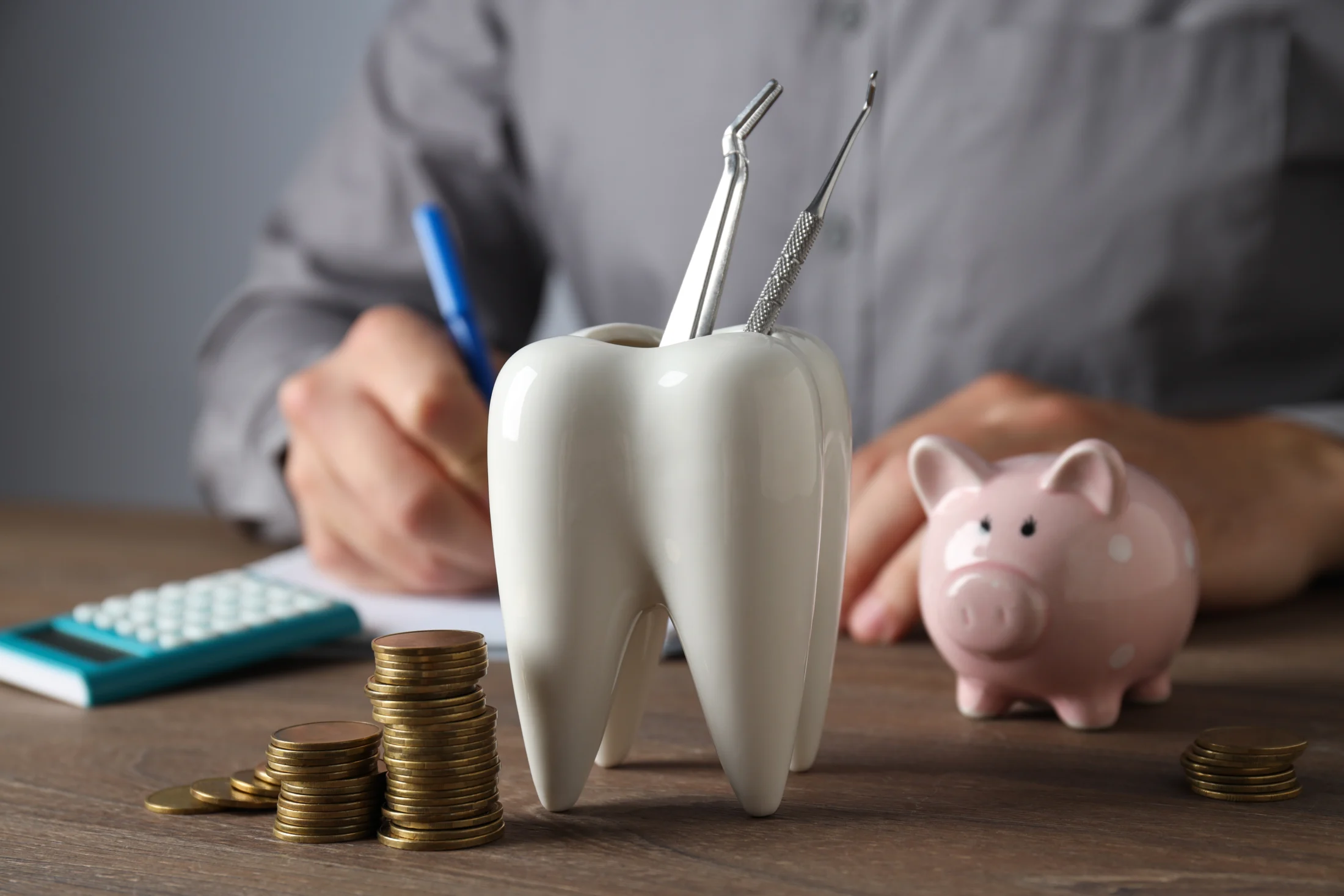 The Ultimate Guide to Dental Loans in Australia; piggy bank, tooh decoration, man writing | Swoosh Finance