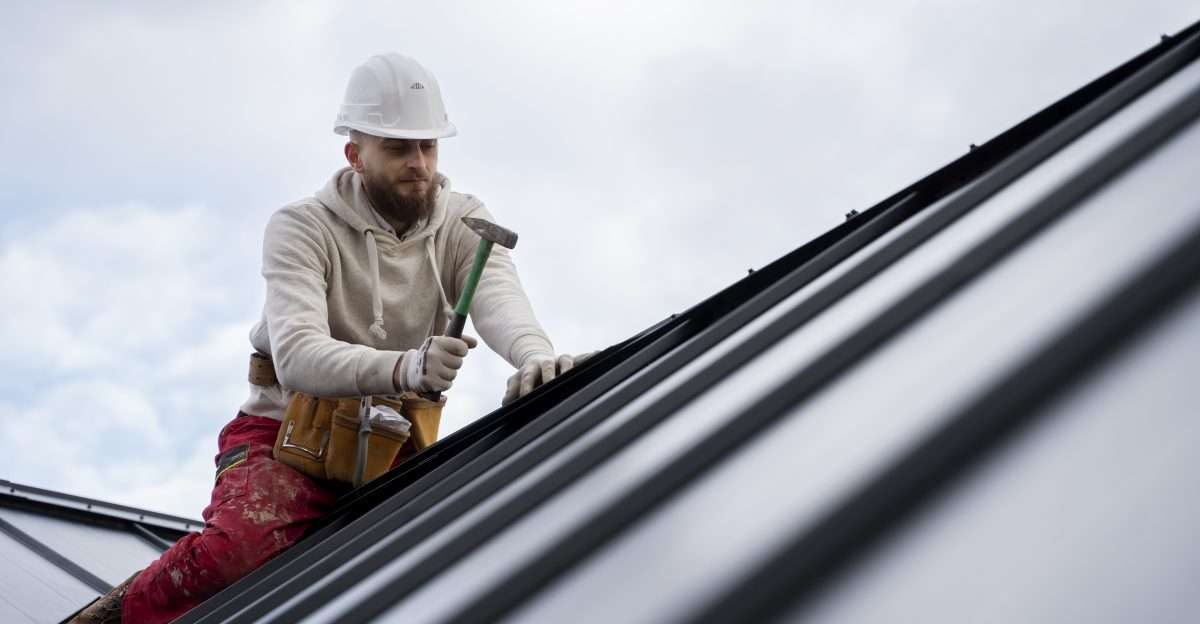 man-working-roof-with-hammer-full-shot