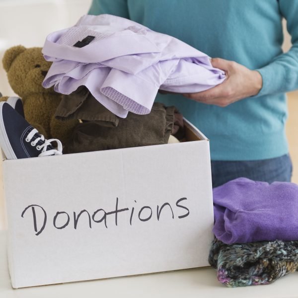 woman putting clothes inside a donations box