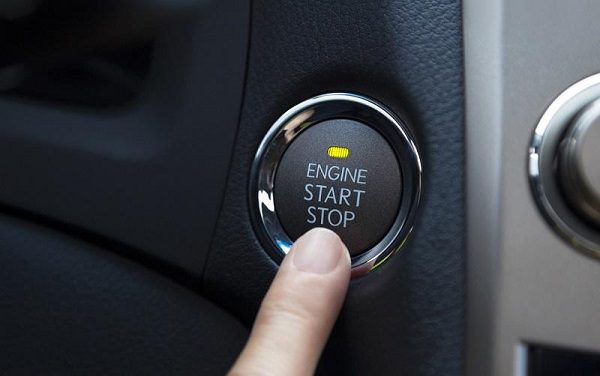 A person putting a finger on the start engine button