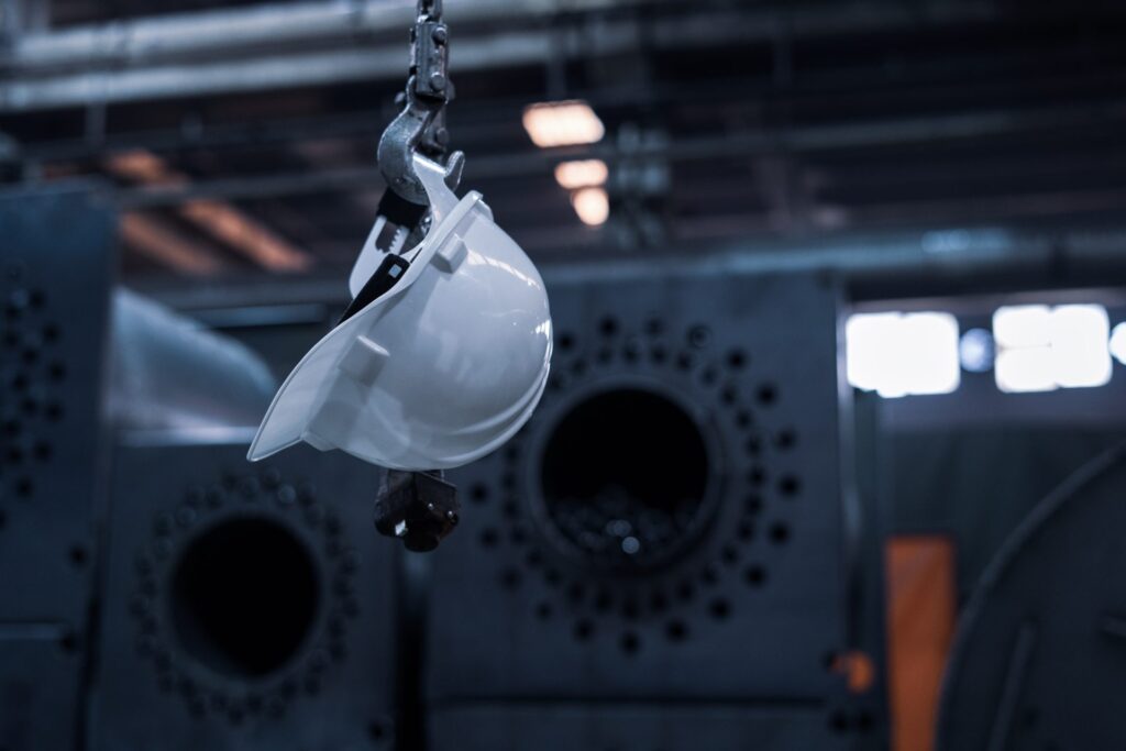 A white safety helmet hanging off a hook