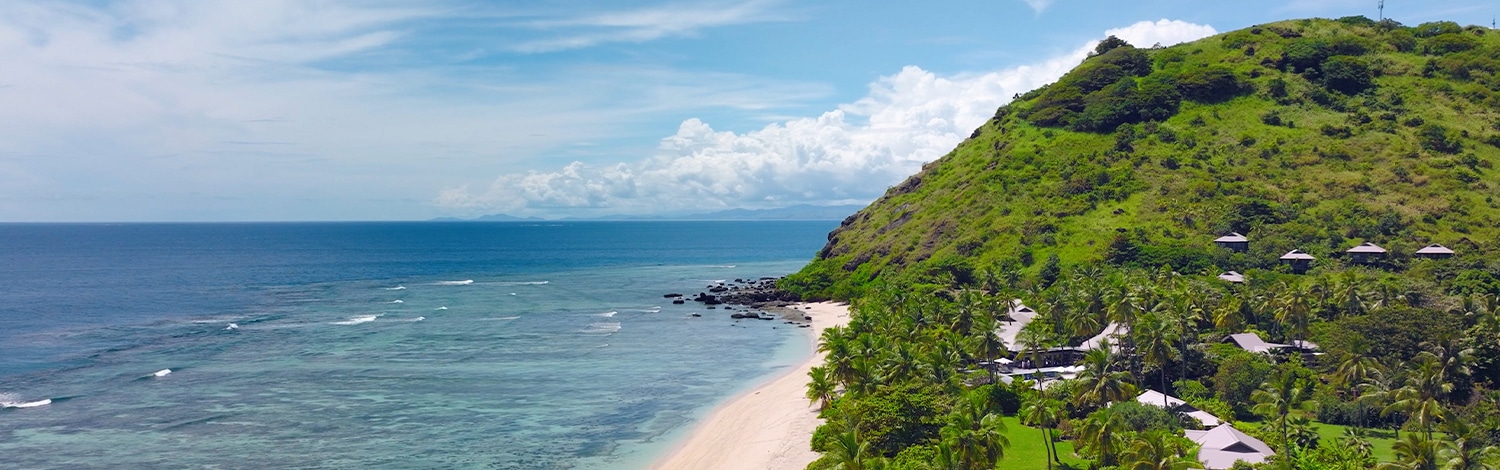 View of mt vomo beacfront and hillside villas and yasawa beach vomo island fiji