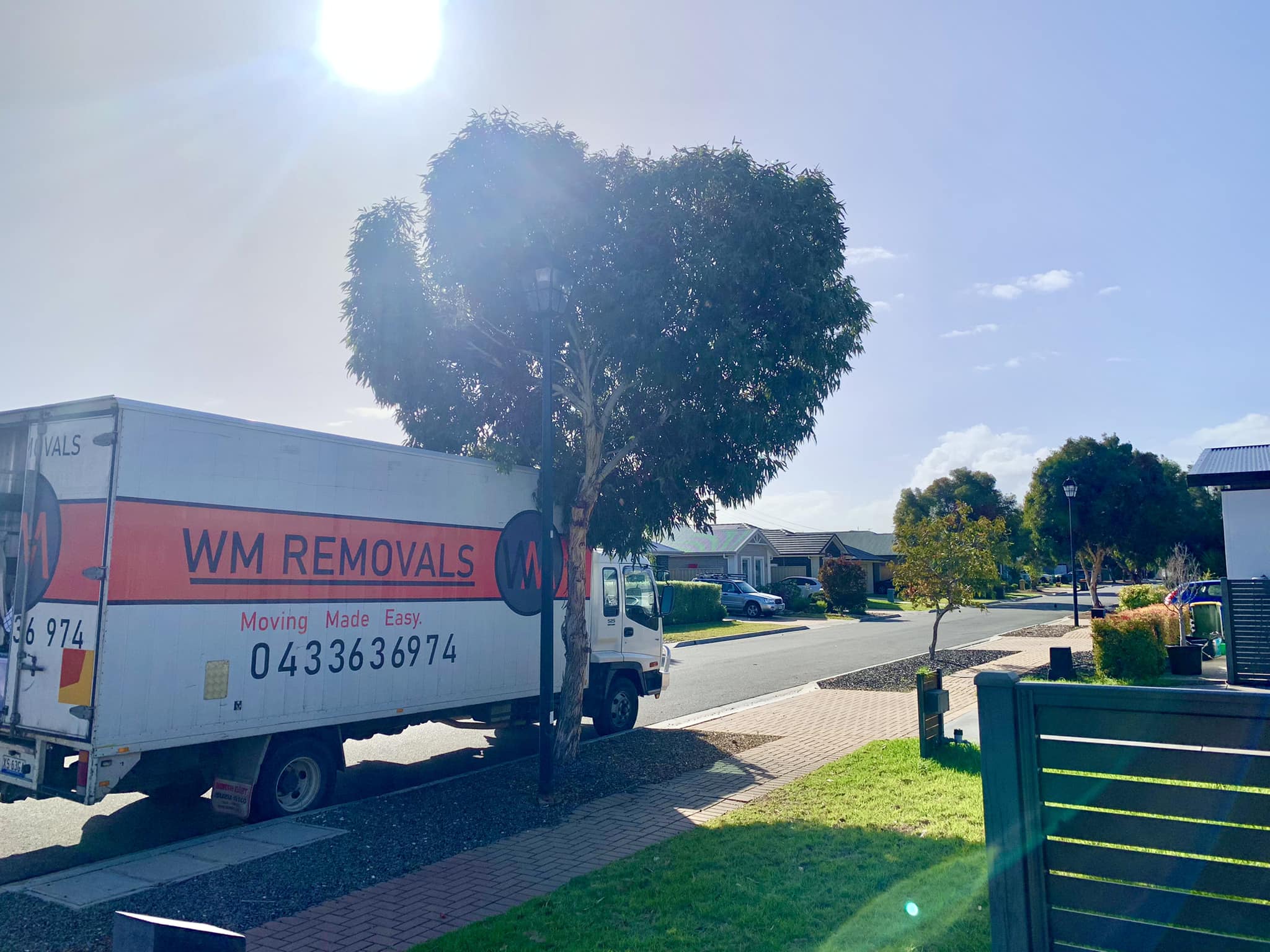 WM Removals truck parked outside near a tree in broad daylight, ready for furniture removals.