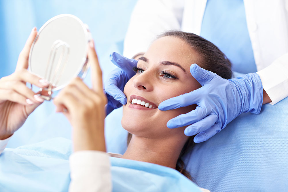 cosmetic dentist showing lady smile in mirror
